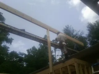 Carpenter setting a ridge beam over a new addition frame — Ice Dam Removal by Roofing Brothers in Dayville