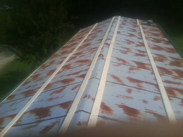 Rusted metal roof panels with new wood purlins before replacement — Storm Damage Roof Repair in Dayville by Roofing Brothers
