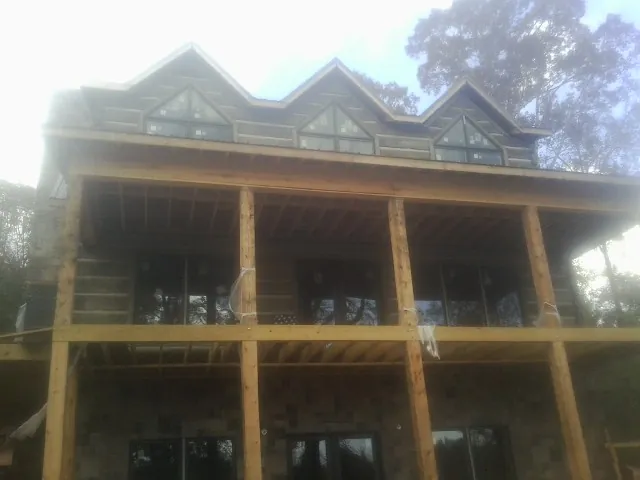 Dormers and porch framing on a large log home under construction — Roof Coating work by our crew in Dayville
