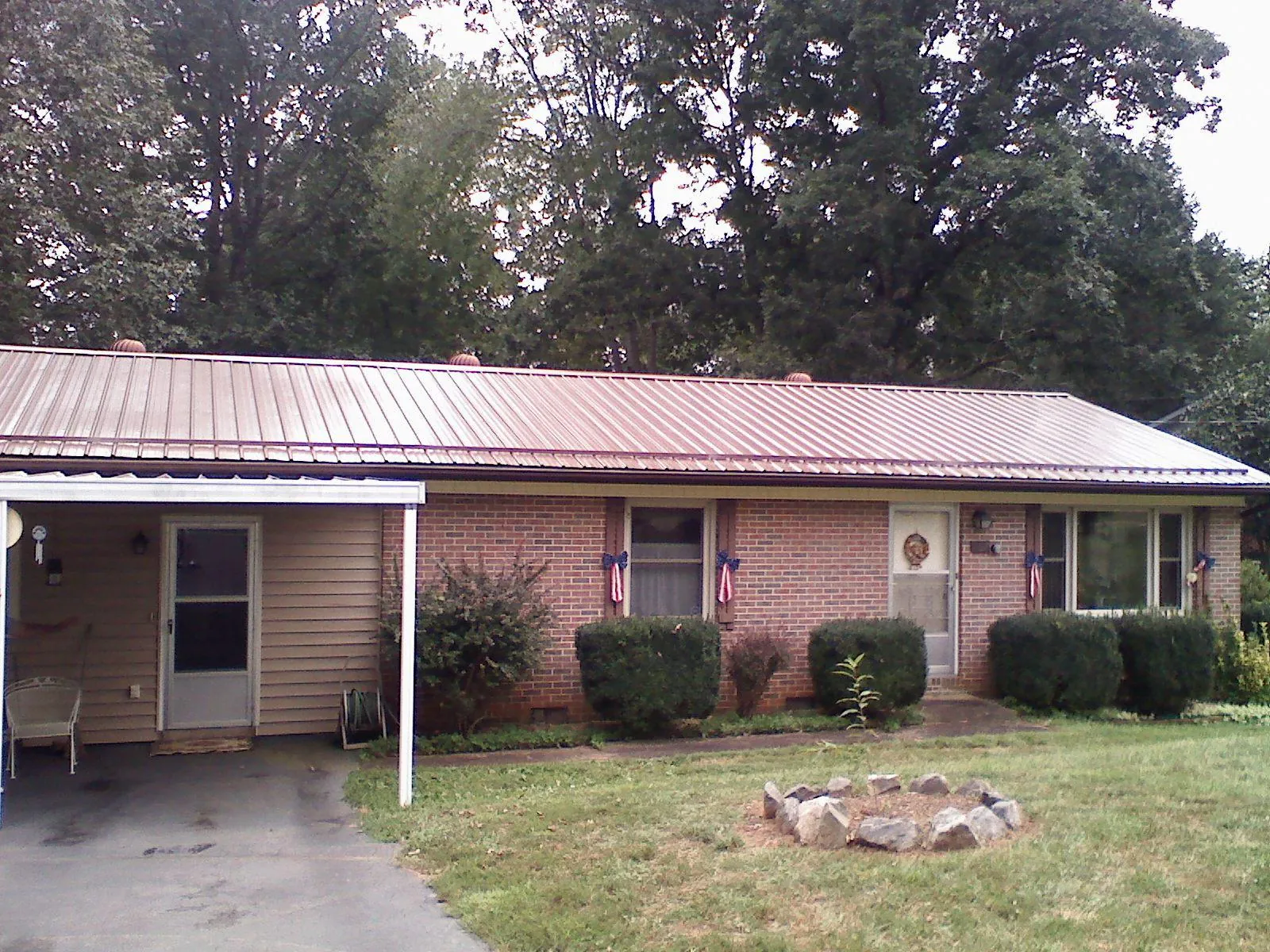 Bronze metal roof and carport on a brick ranch home — Roof Repair work by our crew in Dayville